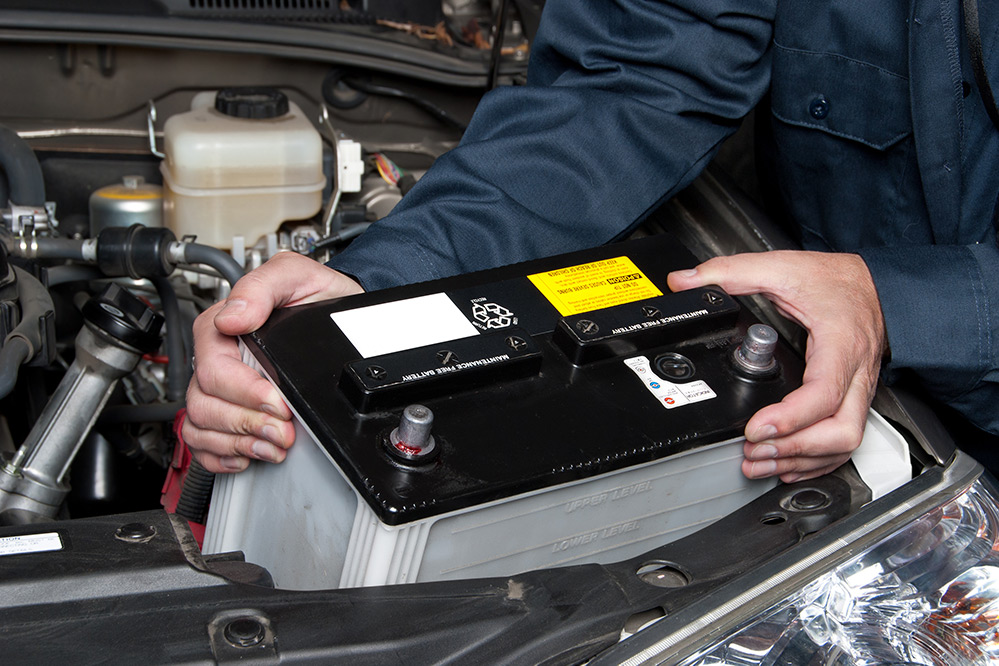 Close up of mechanic installing new car battery