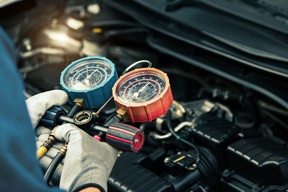 close up of mechanic checking pressure for car