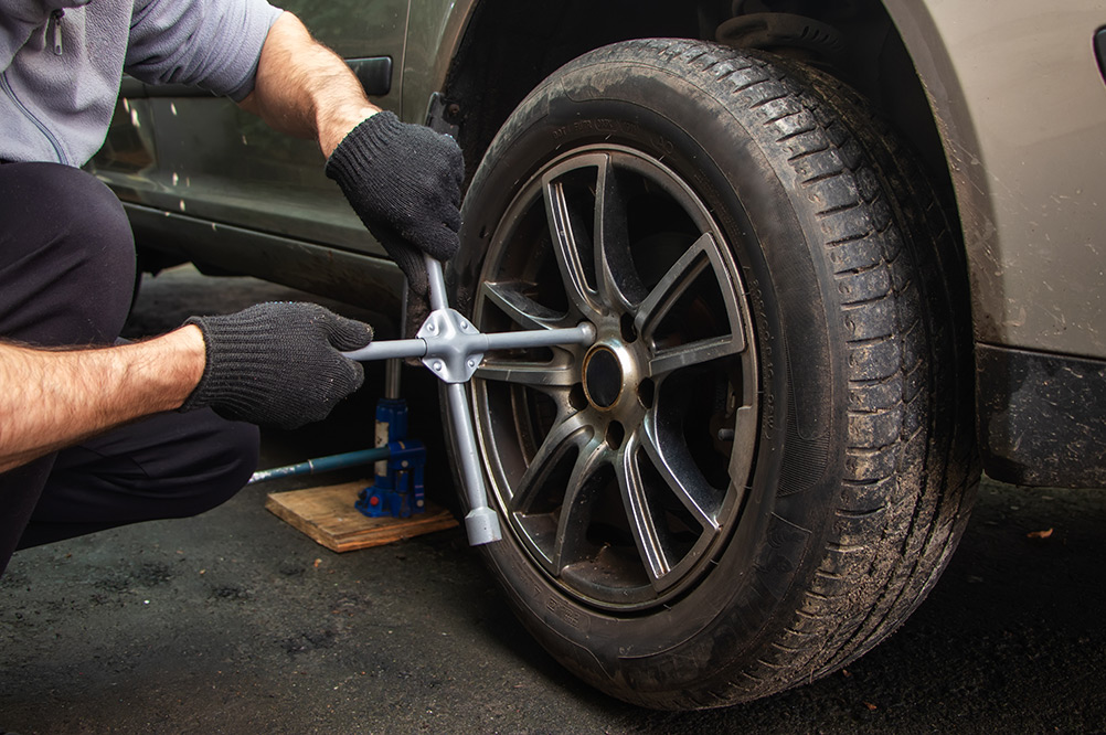 Mechanic removing locking nut on car tyre