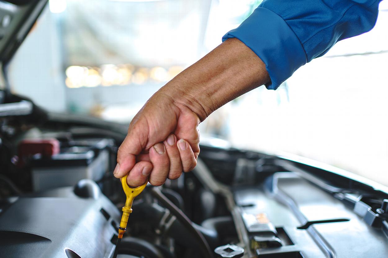 Close up of man doing oil check on car