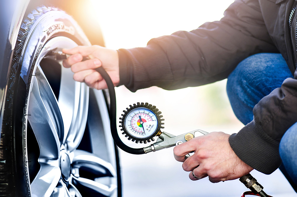 Close up of person checking tyre pressure on car