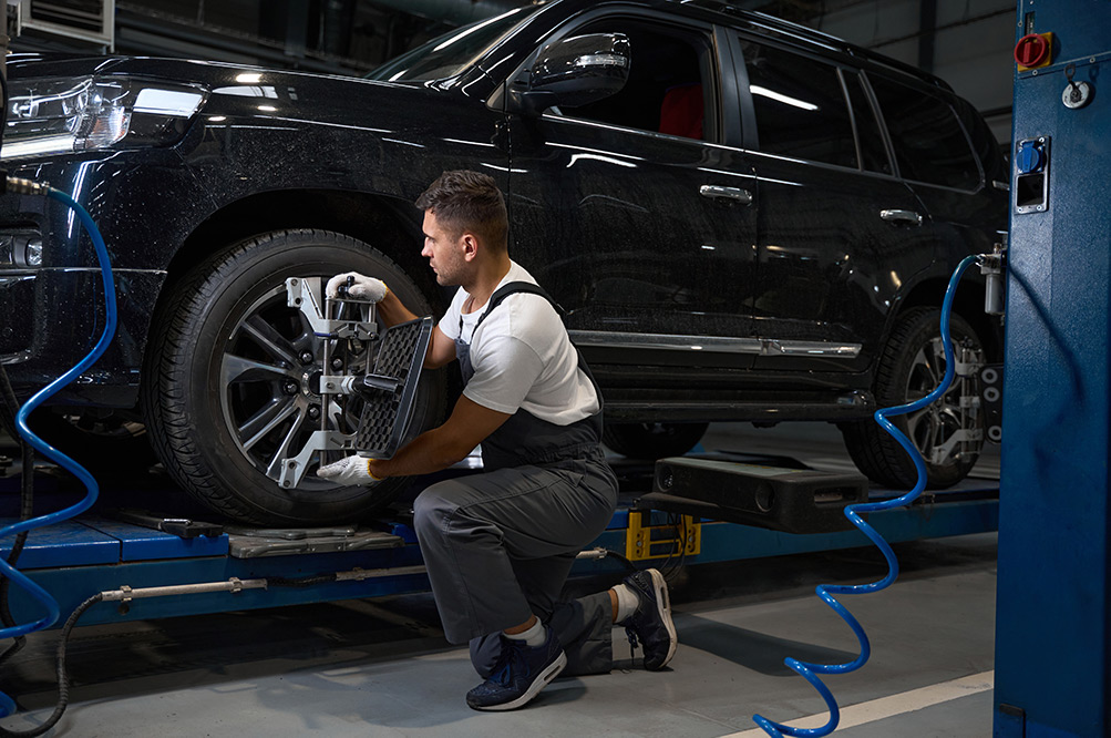 Mechanic fitting new tyre onto car