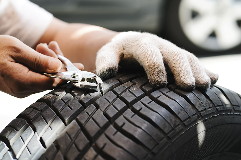 Mechanic pulling nail out of car tyre